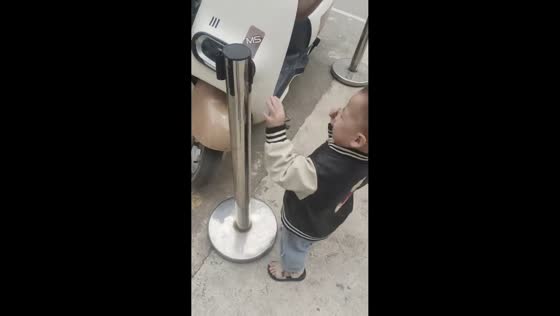 Boy gets playful with stanchion post in Guangdong, China