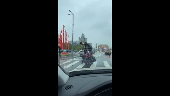 Scooter rider loses balance while carrying heavy load in Moscow, Russia