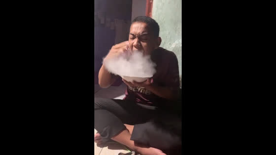 The guy ate such hot noodles that steam came out of his mouth!