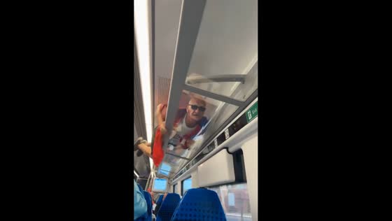 Man climbs onto luggage rack inside public transit in Blackpool, England, UK