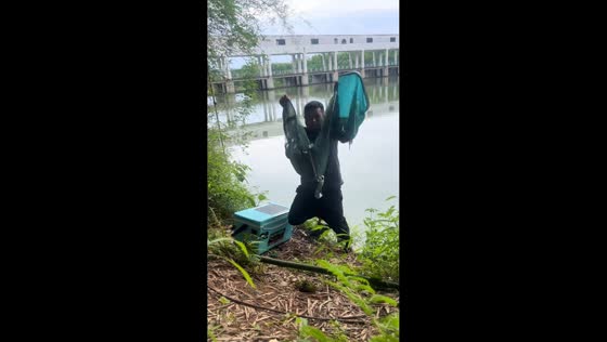 Man slips down muddy riverbank while showing fishing net in Guangdong, China