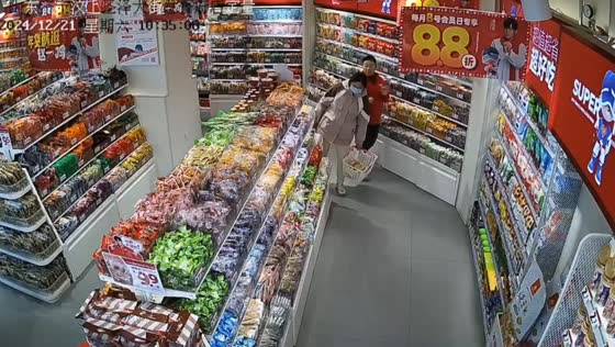 Woman startled by shopper while organizing shelf in Shandong, China