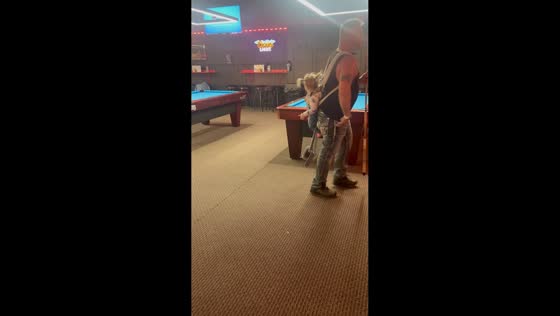 Man plays billiards with toddler on his back in Minnesota, USA
