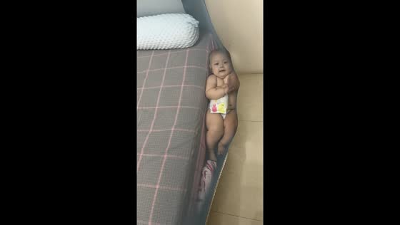 Child safely caught by mosquito net while hanging on bed edge in Shanxi, China