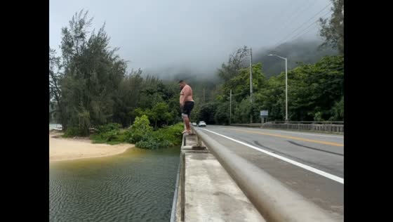 Big river jump sends splash chasing a passing car in Hawaii, USA