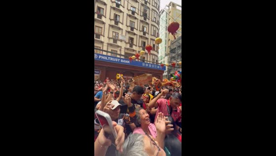 Man uses box to collect money during Chinese New Year blessing in Binondo, Manila, Philippines