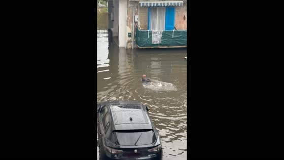 Man swims through flooded streets after torrential rain inundates Nola, Italy