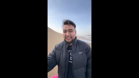 Sandboarder tumbles on snow-covered dune in Xinjiang, China