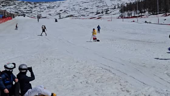 Skier carries person and glides across water at slope in Xinjiang, China