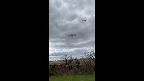 Helicopter doing Electromagnetic Survey over Truro, England, UK