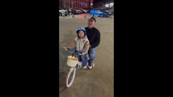 Father and daughter fall backward during playful bike ride in Shandong, China
