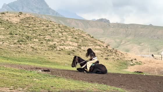 Woman startled as horse suddenly rolls on the ground in Xinjiang, China