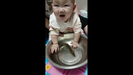 Child joyfully catches fish in bowl in Heilongjiang, China