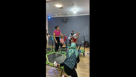 Amusing trampoline mishap: laughter and support amidst slippery fun