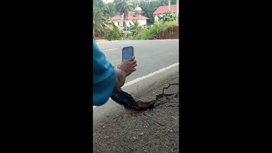 Road collapses into water as people cheer in Jambi, Indonesia