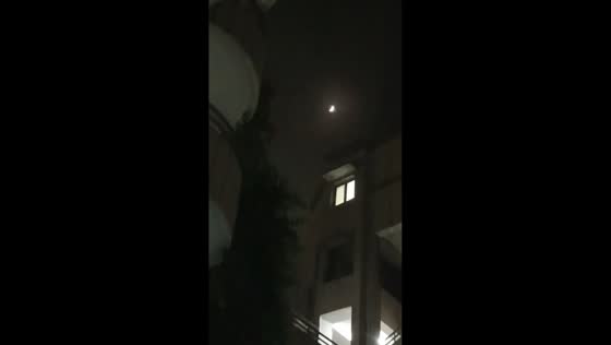Nighttime lunar eclipse over cityscape in Delhi, India