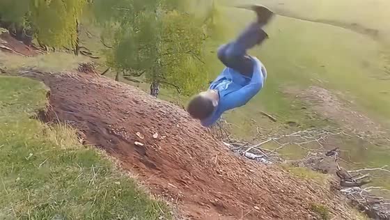 Boy tumbles after attempting a backflip off a hillside in Russia