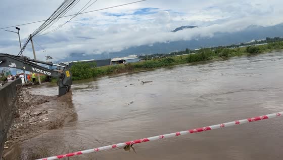 Excavator removes debris and mud as floodwaters rise near Beisha Bridge in Shaanxi, China