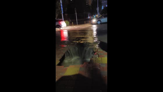 Floodwaters rush into damaged sidewalk drain in Hebei, China