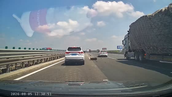 Blown-out tire rolls across a highway as vehicles narrowly avoid it in Liaoning, China