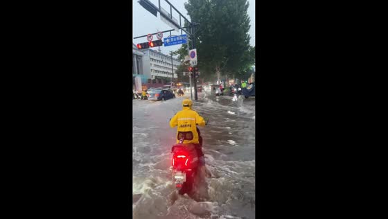 Floodwaters sweep away deliveryman's motorcycle and box in Shandong, China