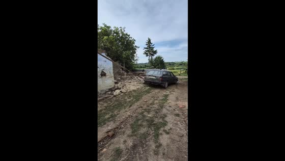 Car struggles to pull down house wall in Slobidka-Okhrimovetska, Ukraine