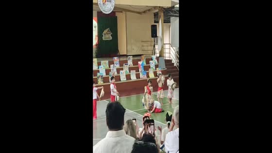 Boy helps classmate with slippers during dance performance in Manila, Philippines
