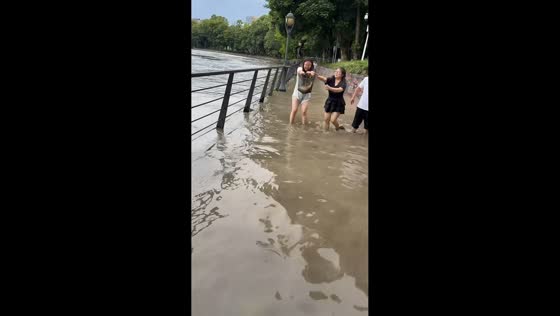 Residents catch fish by hand after Jinjiang River floods in Sichuan, China
