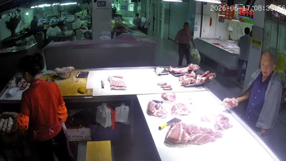 Elderly man takes meat from market stall in Jiangsu, China