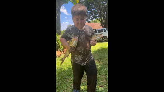 Boy proudly carries two large fish in Doutor Maurício Cardoso, Brazil