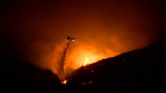 Helicopters battle wildfire in Mentone, California, USA