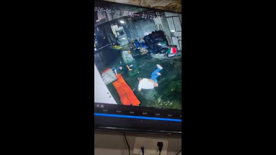 Two men slip and fall in sync on warehouse floor in Guangdong, China