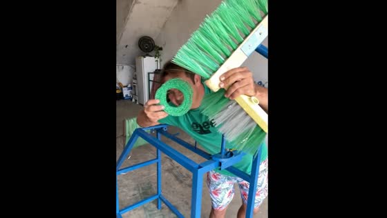 Man makes broom using recycled plastic bottles.