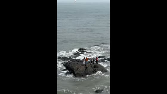 People stranded on rock formation during high tide in Fujian, China