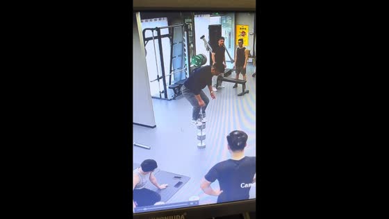 Man balances on stacked dumbbells in gym in Guangdong, China