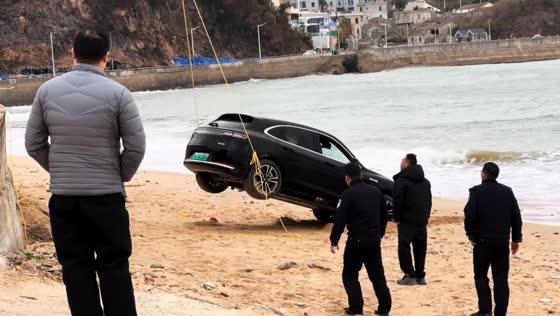People rescue submerged AITO M5 stuck on beach in Pingtan Island, Fujian, China