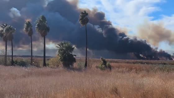 Flames and smoke from wetland burn in Topock Marsh, California, USA
