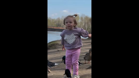 Toddler eats the bread during duck feeding in Krasnoyarsk, Russia