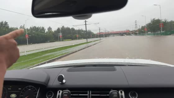 Vehicle drives through flooded highway in Liaoning, China