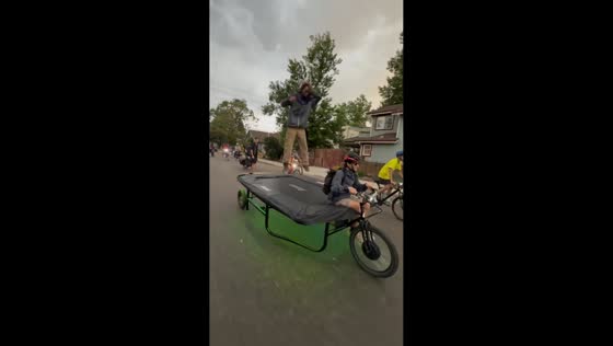Man rides trampoline bicycle surrounded by cyclists in Boulder, USA