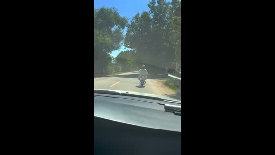 E-bike rider falls into roadside gutter after smiling at friend in Gansu, China