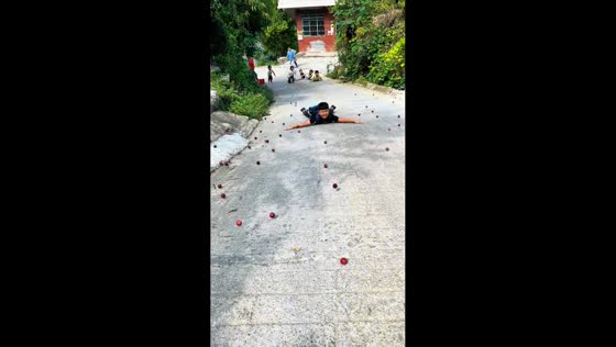 Kids lie on road to catch fallen fruit in Guizhou, China