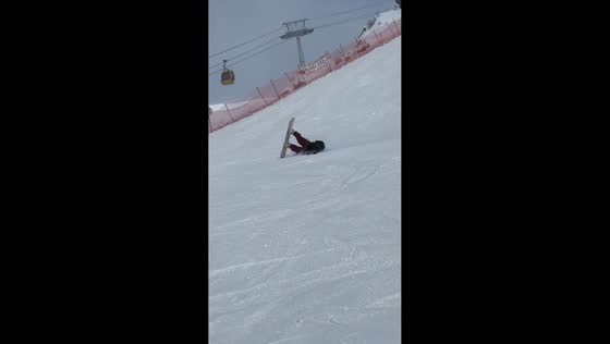 Snowboarder loses balance while descending a snowy hill in Zhejiang, China