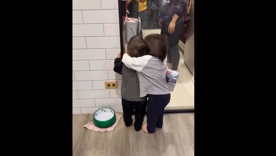 Twin comforts younger brother while their mother cooks in Taiwan