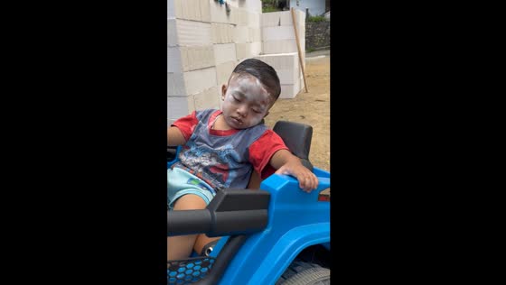 Sleepy 18-month-old Nizam dozes off in blue toy car