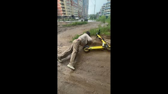 Teen slips and falls into mud while pushing scooter in Domodedovo, Russia