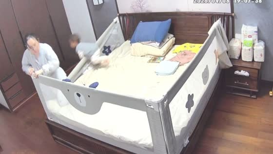 Toddler falls from a bed while grandmother sets up a playpen in Hunan, China