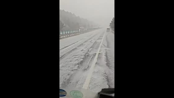 Hailstorm turns highway white as vehicles navigate icy conditions in Liaoning, China