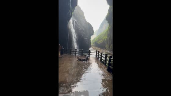 Woman slips and falls while running on wet ground at Tongling Grand Canyon Falls, China