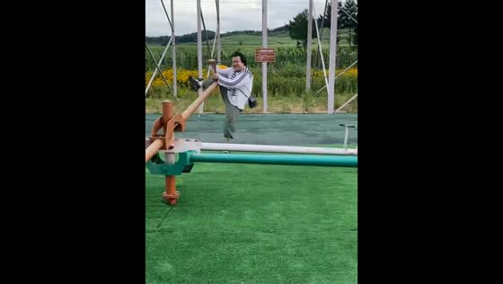 Man struggles to balance on rotating seesaw in Jilin, China